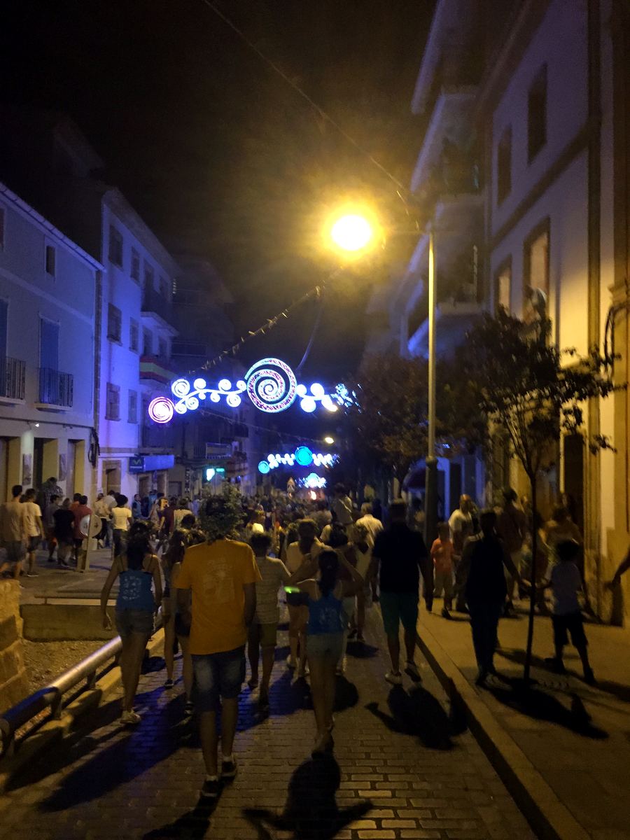 Evening crowds under festival string-lights along the Arenal dining strip in Jávea