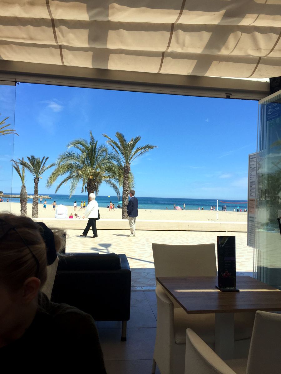 Morning coffee with a view of the Arenal beach through the café glass