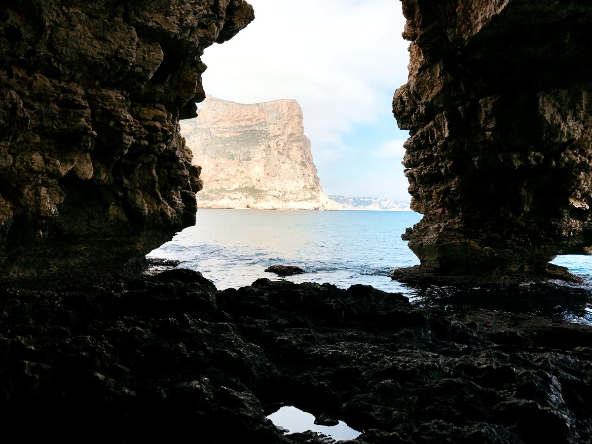 View through the rock arch of the Cova Tallada sea cave near Jávea