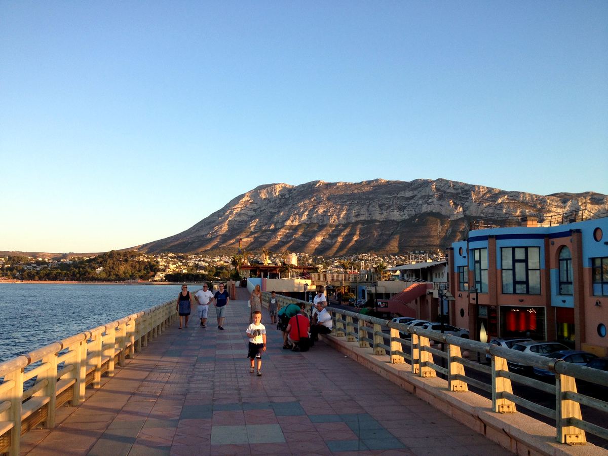 Dénia’s waterfront from the harbour breakwater, Montgó rising behind in golden light