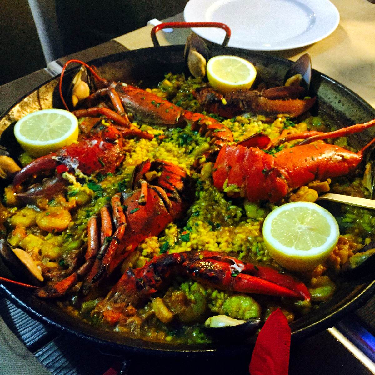 A lobster paella served in Jávea — saffron rice, lemon and whole bogavante