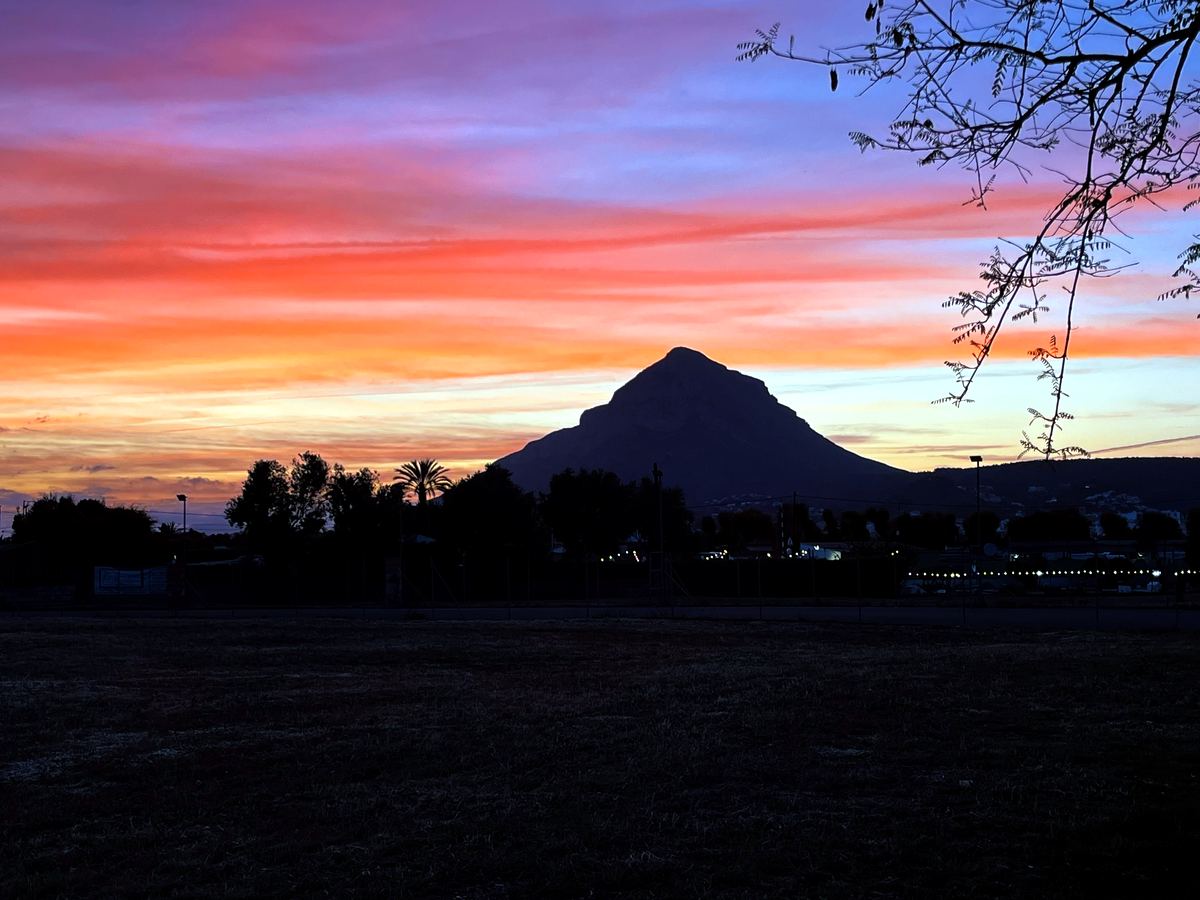 Montgó silhouetted against a fiery orange and pink sunset over Jávea