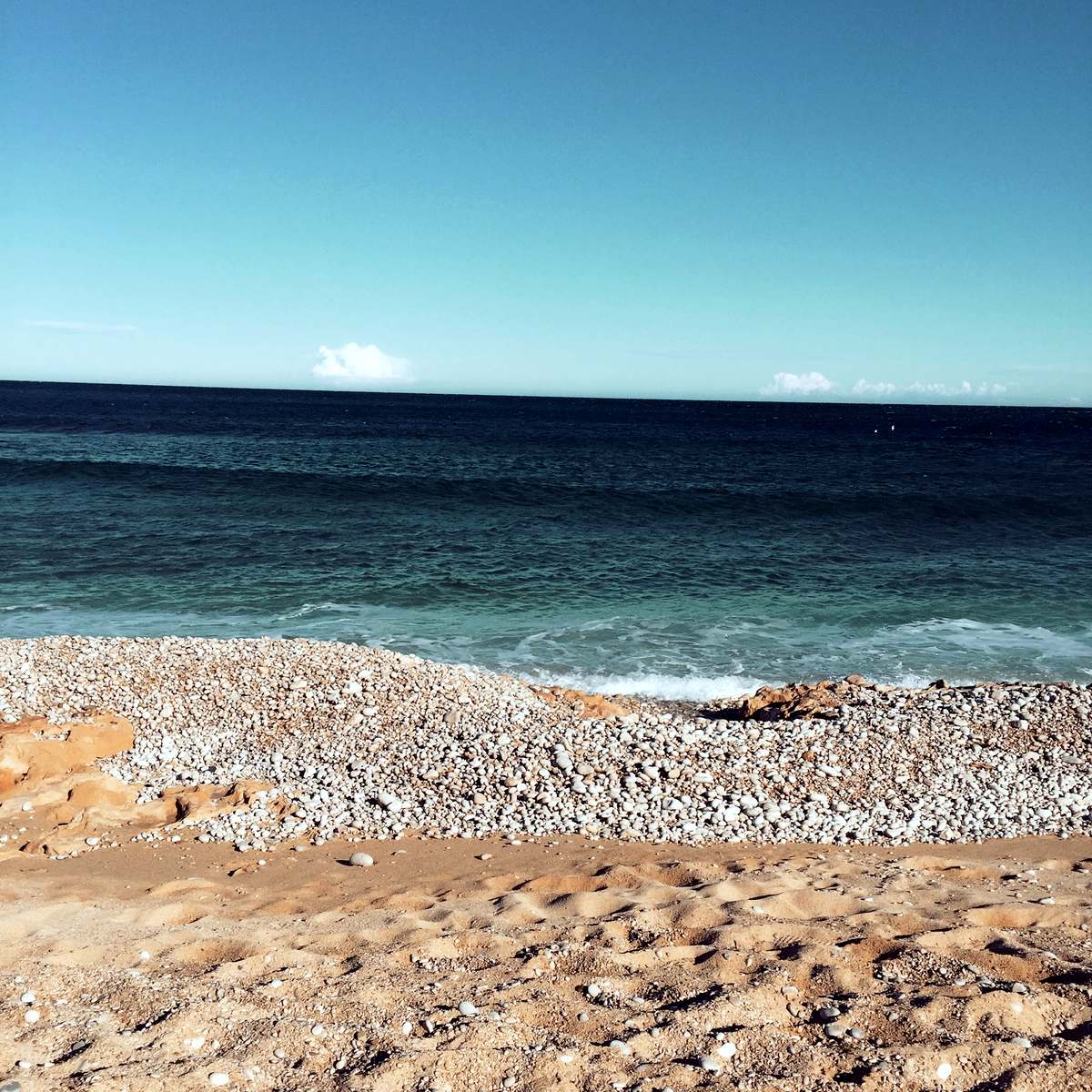 White-pebble shoreline and clear winter sea on Javea’s Muntanyar coast