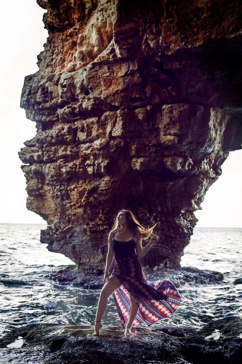A sea-carved overhanging rock formation towering over the shoreline