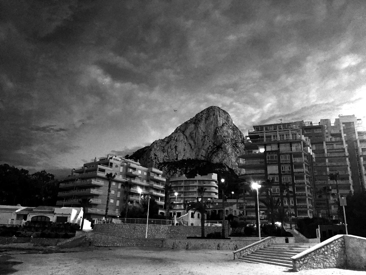 The Peñón de Ifach rising behind Calpe’s beachfront under a moody evening sky